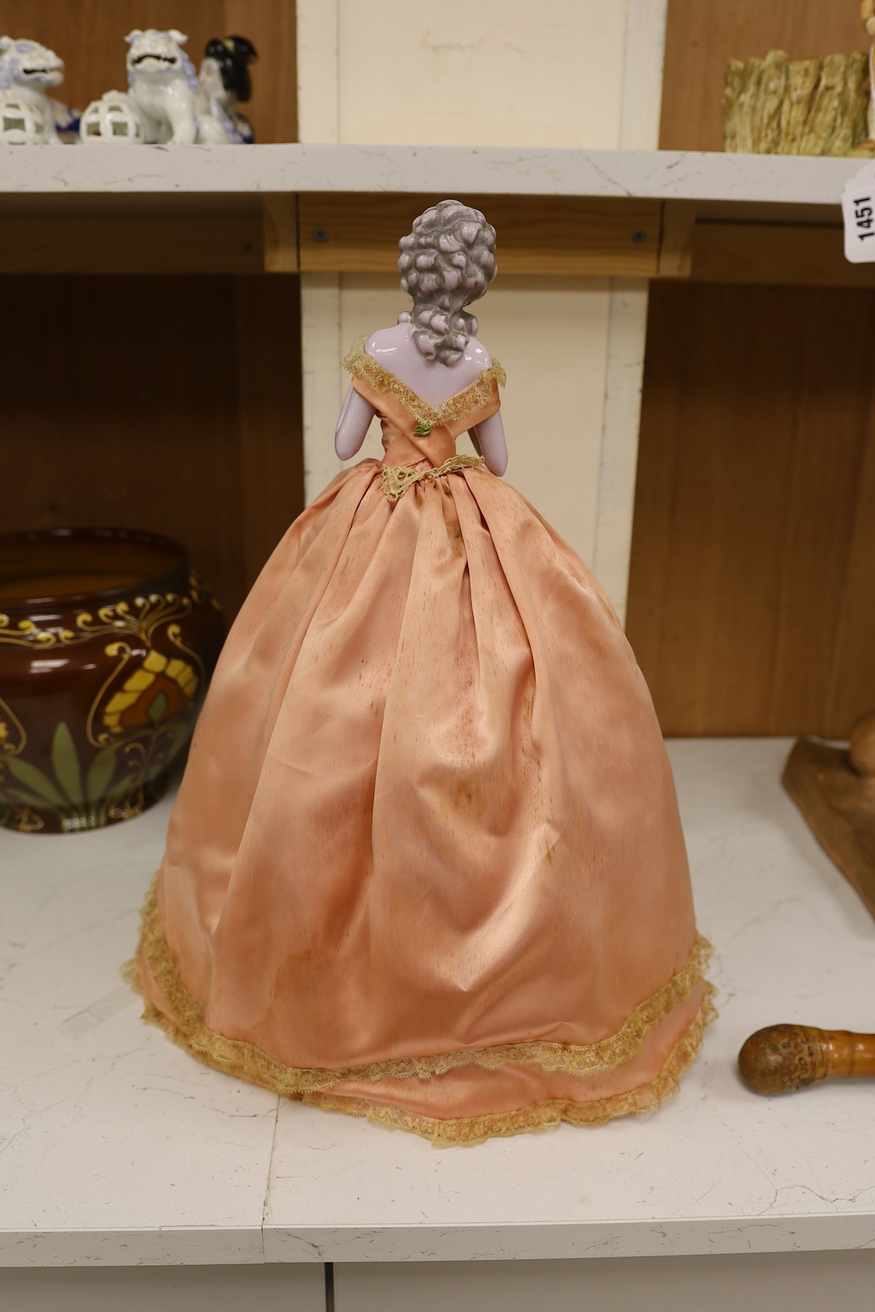 A 1920’s German porcelain 'pin dolly' with tea cosy dress, 46cm high. Condition - good some marks to the silk of cosy/dress